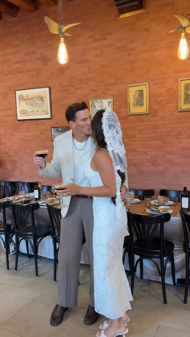 A bride and groom dancing in a brick-walled dining room