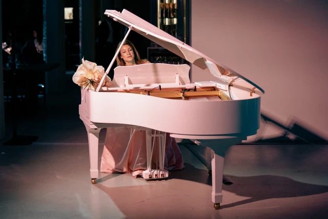 Giulia Vazzoler at a white grand piano under a soft pink light